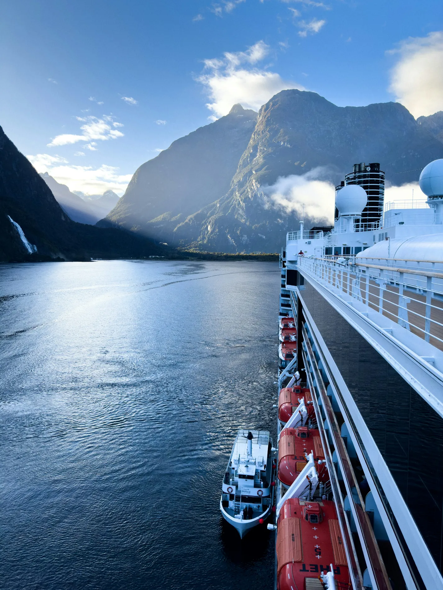 Cruise ship sailing between dramatic mountains